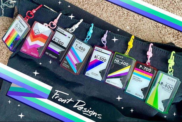 A keychain of pride flags combined with VHS tape box designs